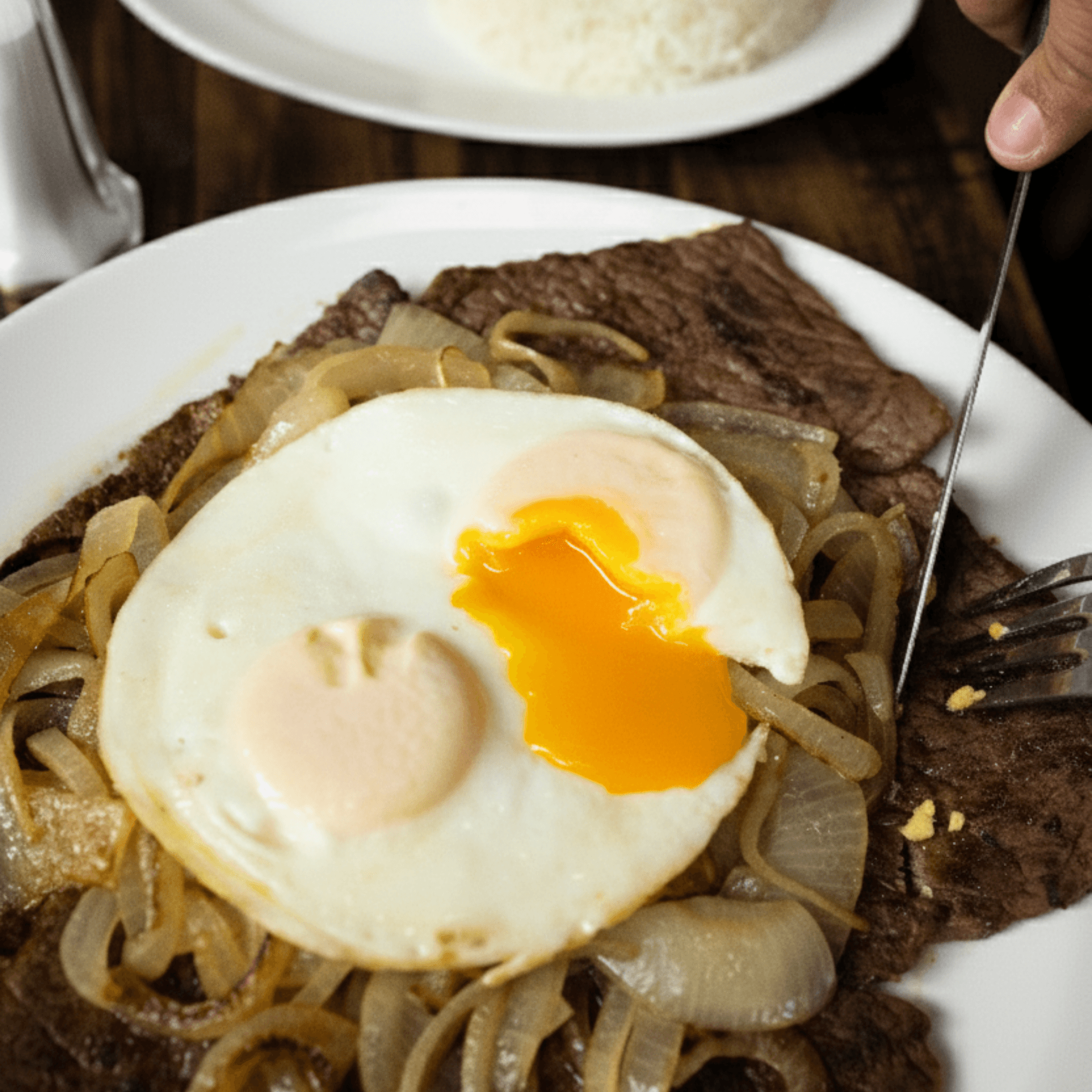 Bistec Encebollado Con 2 Huevos Fritos