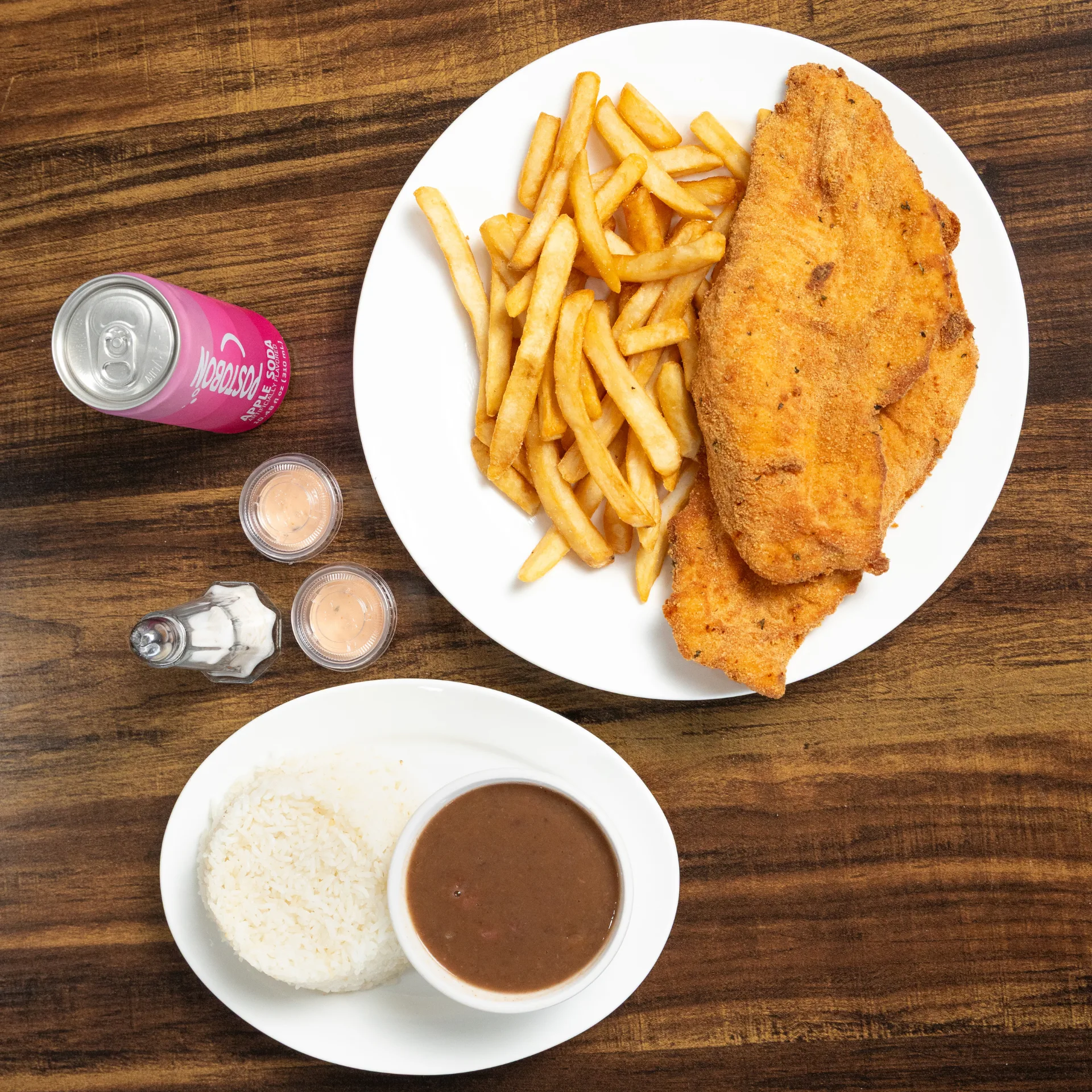 Chuleta de pollo con papas fritas, arroz y frijoles
