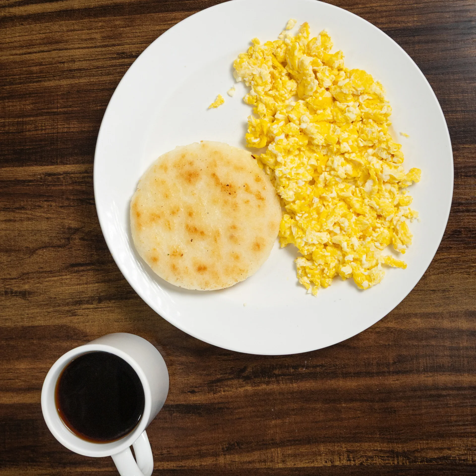 huevos revueltos y arepa con queso